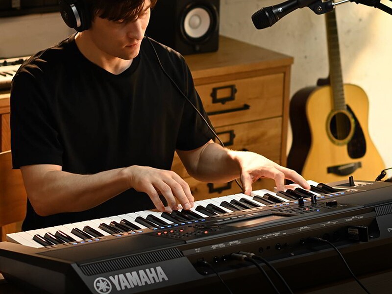 演奏者在 Yamaha 數位工作站 PSR-SX720+ 上彈奏和弦的照片