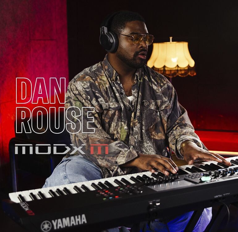 Visual of Dan Rouse playing a synthesizer in a performance scene