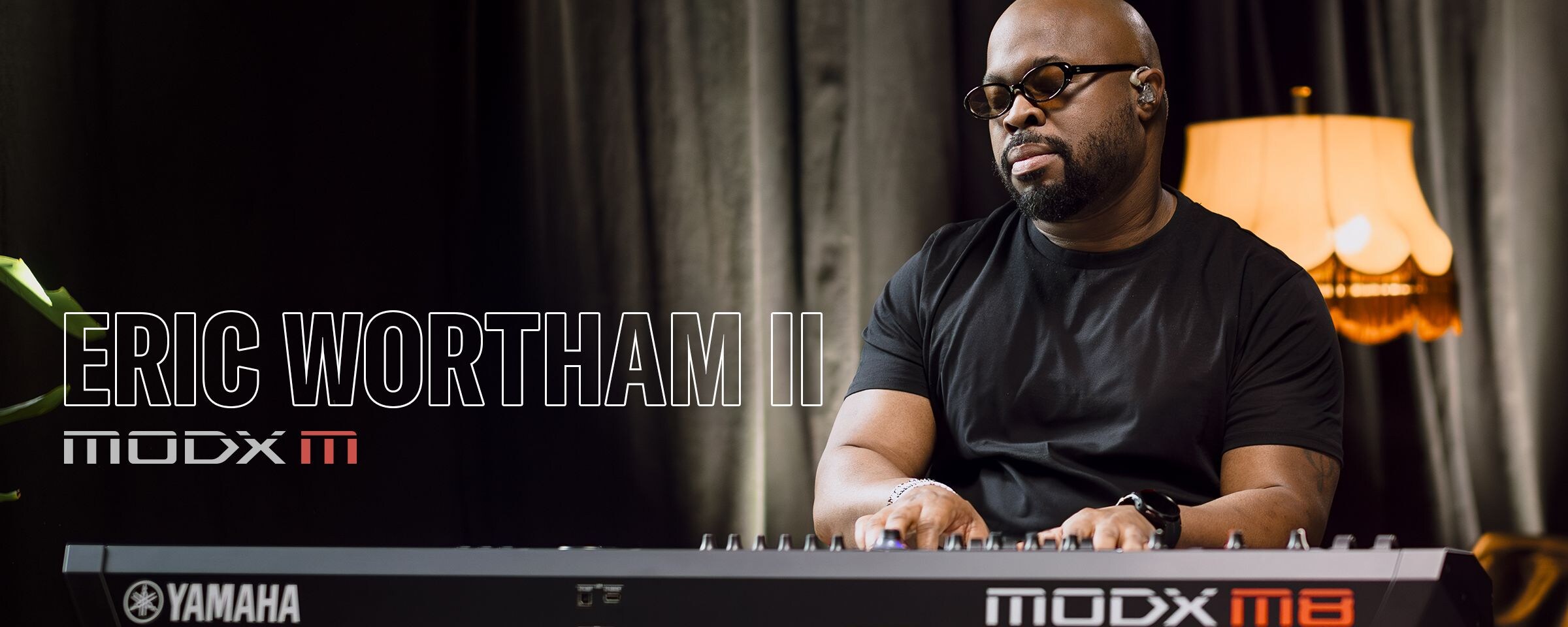Visual of Eric Wortham II playing a synthesizer in a performance scene