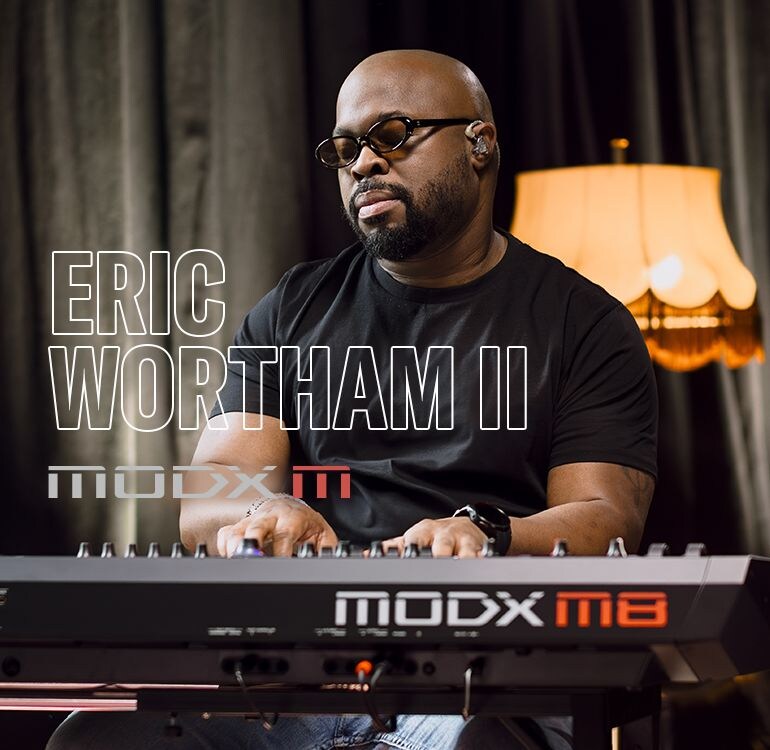 Visual of Eric Wortham II playing a synthesizer in a performance scene