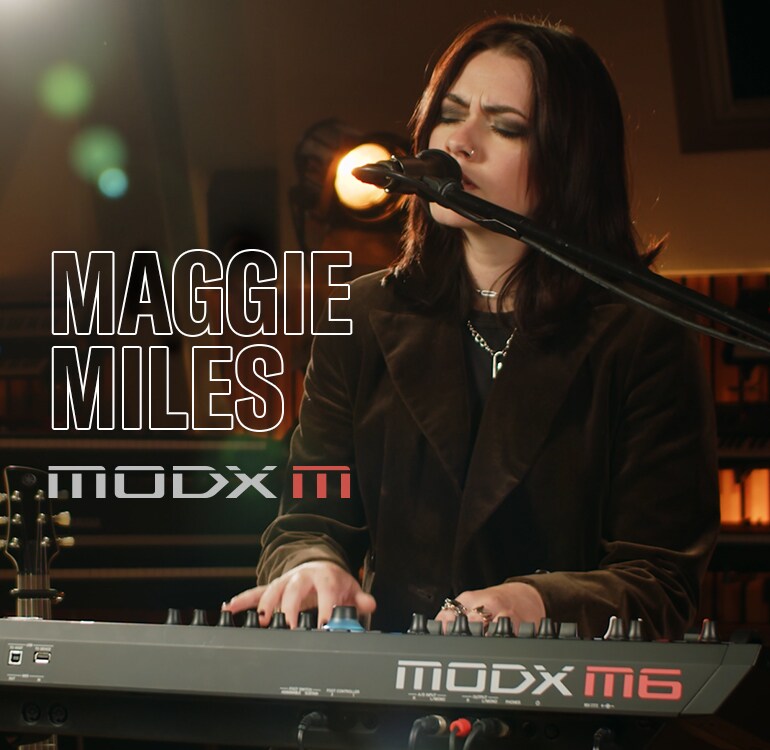 Visual of Maggie Miles singing while playing a synthesizer in a performance scene