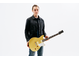 Chris Buck 站立並手持他的簽名款 Revstar RS02CB 吉他