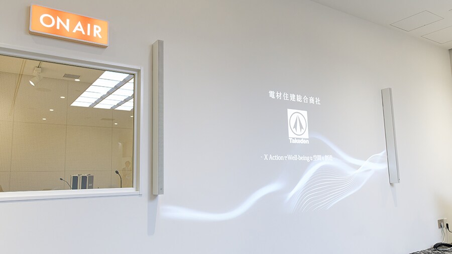 帶有牆面投影顯示器和已安裝線陣列喇叭的品牌區